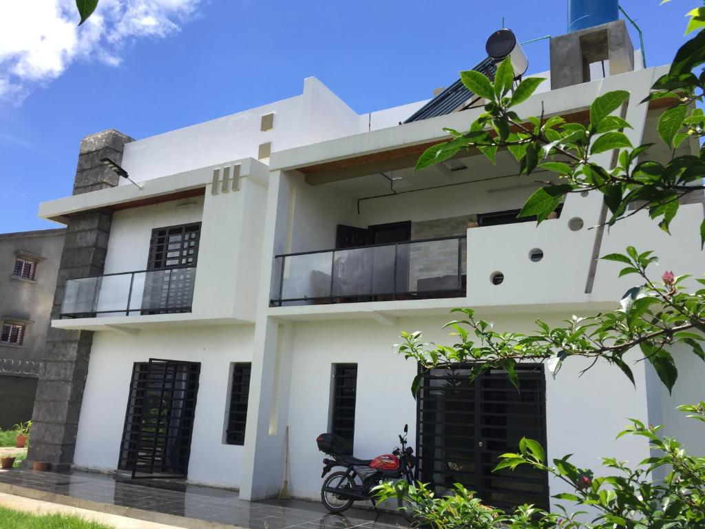 Sanda GuestHouse في أنتسيرابي: بيت أبيض مع شرفة