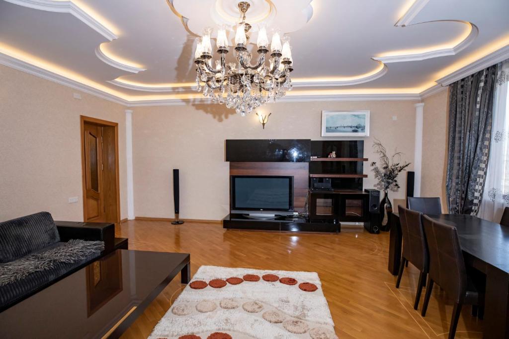 sala de estar con lámpara de araña y comedor en WAQAS RESIDENCE INTERNATIONAL, en Baku