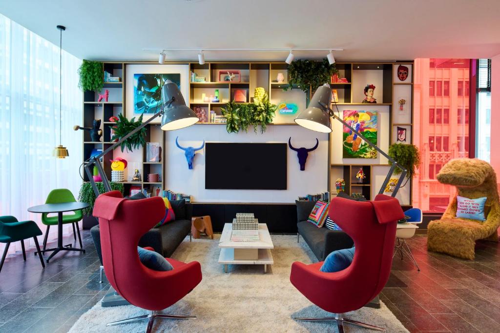 un soggiorno con sedie rosse e TV a schermo piatto di citizenM Austin Downtown ad Austin