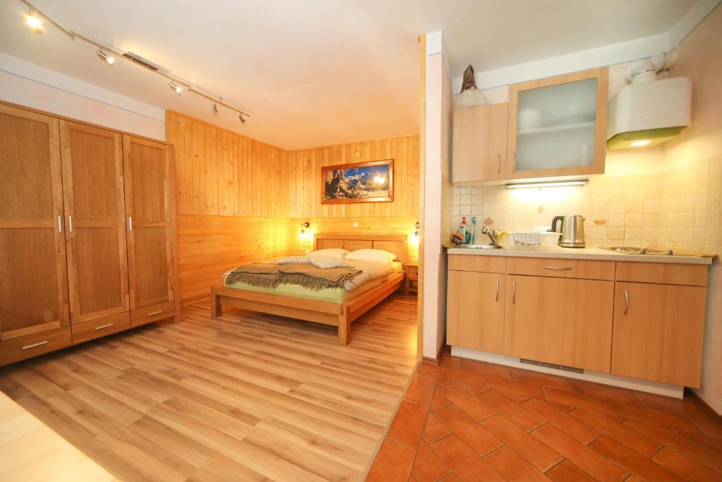 a bedroom with a bed and a kitchen at Apartma Felix in Kranjska Gora
