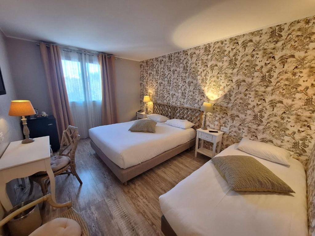a hotel room with two beds and a desk at Best Western L&#39;Orangerie in Nîmes