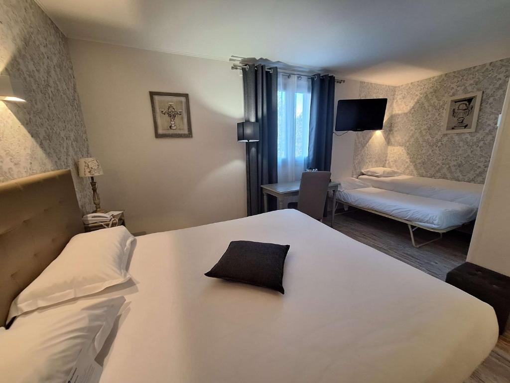 a hotel room with a bed and a desk at Best Western L&#39;Orangerie in Nîmes