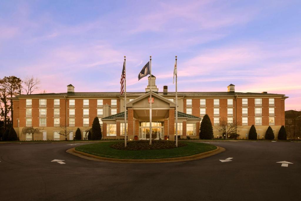 duży budynek z flagami przed nim w obiekcie Hilton Garden Inn Williamsburg w mieście Williamsburg