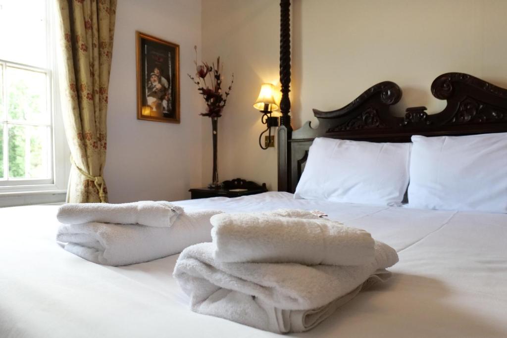 Un dormitorio con una cama con toallas blancas. en The Mary Arden Inn en Stratford-upon-Avon