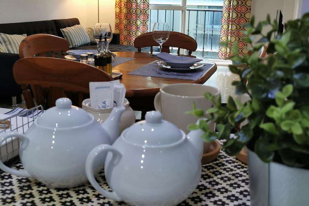 una mesa con 4 tazas de té blanco y un comedor en Apartamento en la Cala del Moral, en Cala del Moral