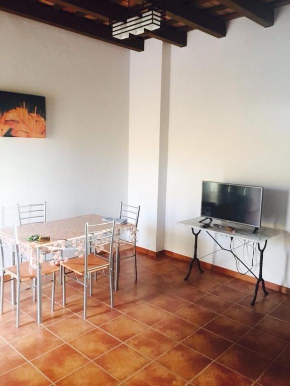 a dining room with a table and chairs and a television at Apartamentos Daper in Facinas