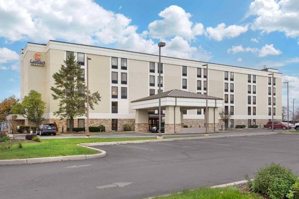 un gran edificio blanco con aparcamiento en Comfort Inn & Suites, en Johnstown