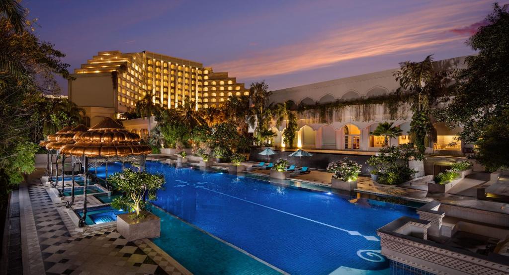 a hotel with a large swimming pool at night at Taj Krishna in Hyderabad