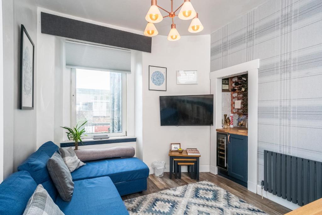 sala de estar con sofá azul y TV en Pass the Keys Trendy Historic flat sleeps 4 to 6 near Leith Shore, en Edimburgo