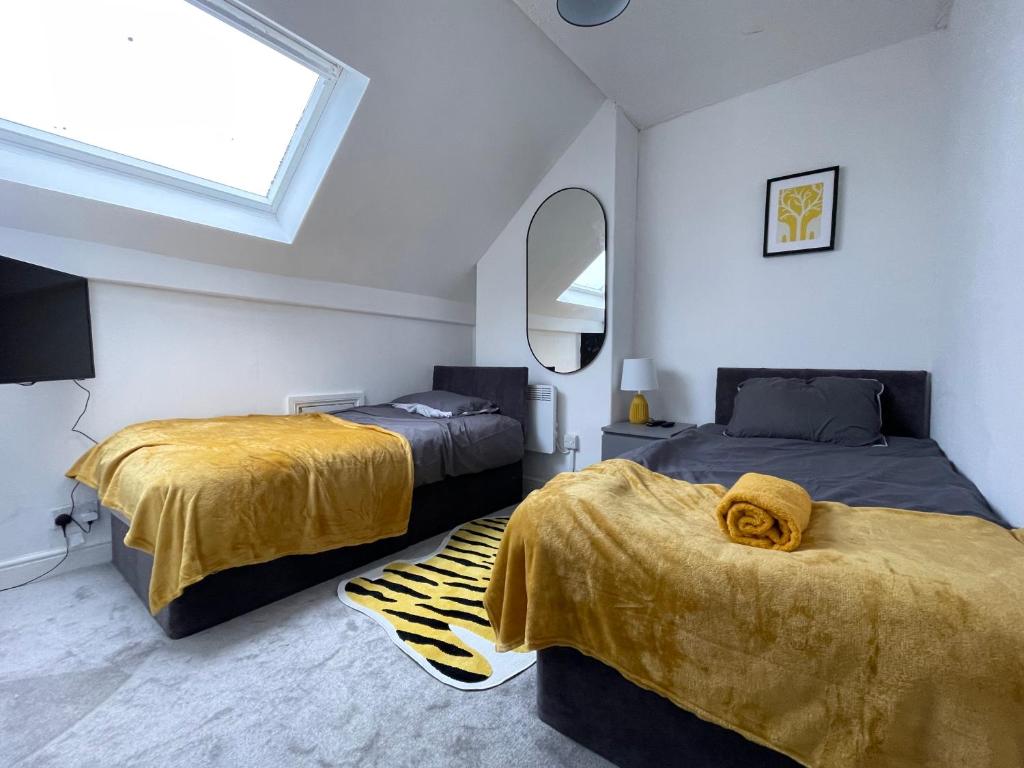 a bedroom with two beds and a mirror at Inviting 1-Bed Apartment in Leeds in Leeds
