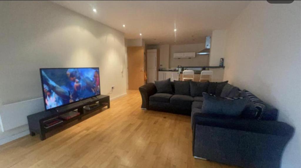 a living room with a couch and a flat screen tv at Remarkable 2-Bed Apartment in Leeds in Leeds