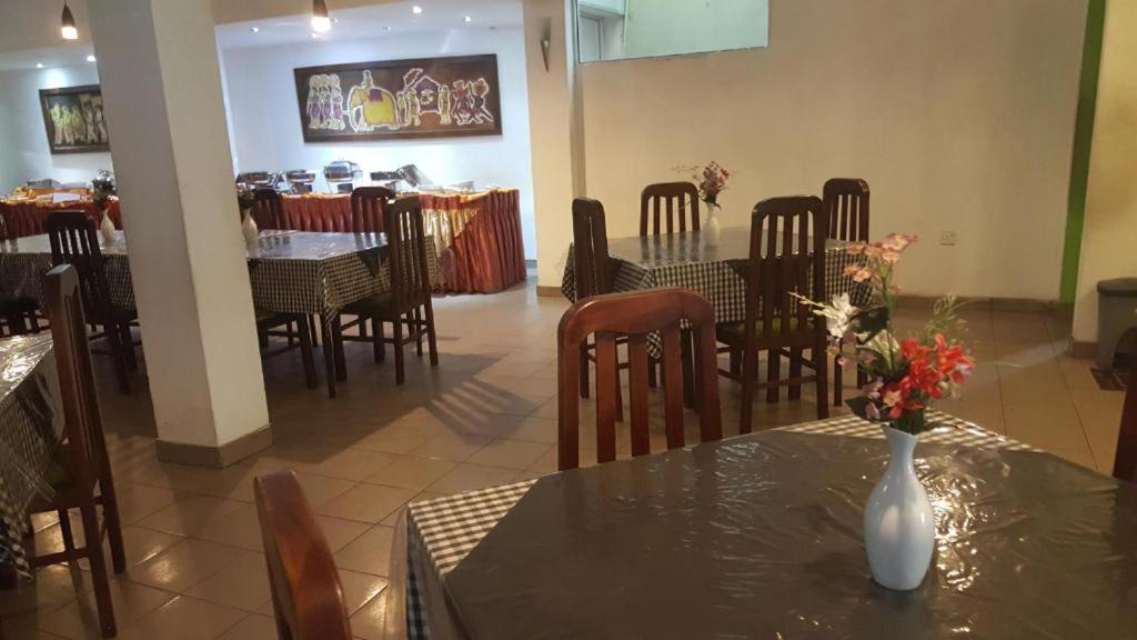 a dining room with tables and chairs and a vase on a table at Victory Inn Monaragala in Monaragala