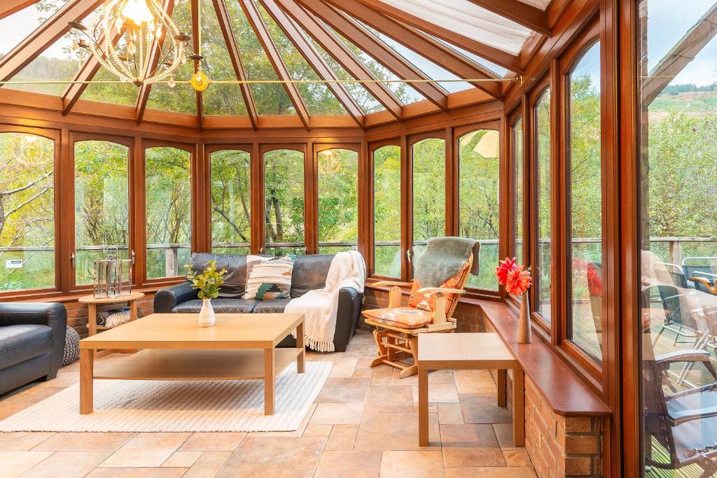 a conservatories living room with a glass roof at The Trail by Afan Valley Escapes in Cymmer