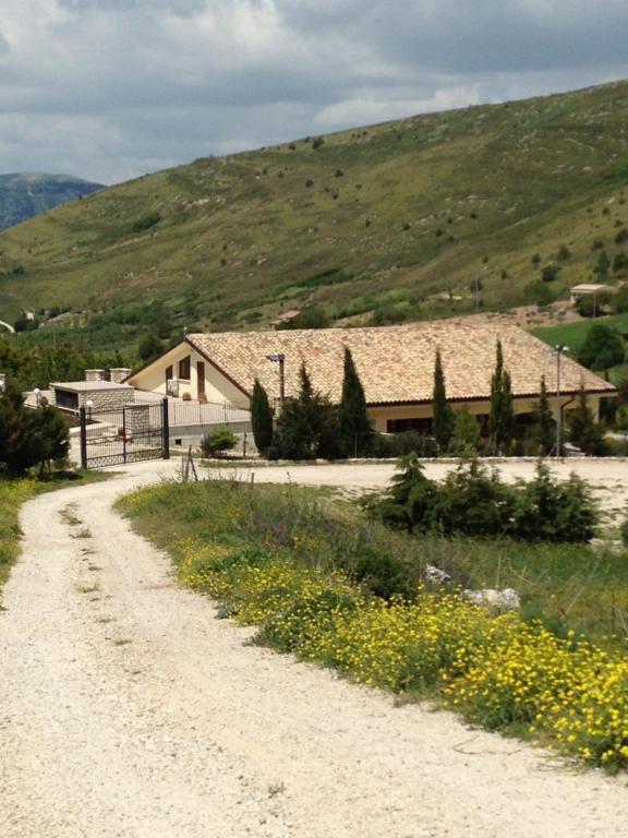 a dirt road in front of a building with a mountain at Agriturismo Serra Moneta in Santo Stefano Quisquina