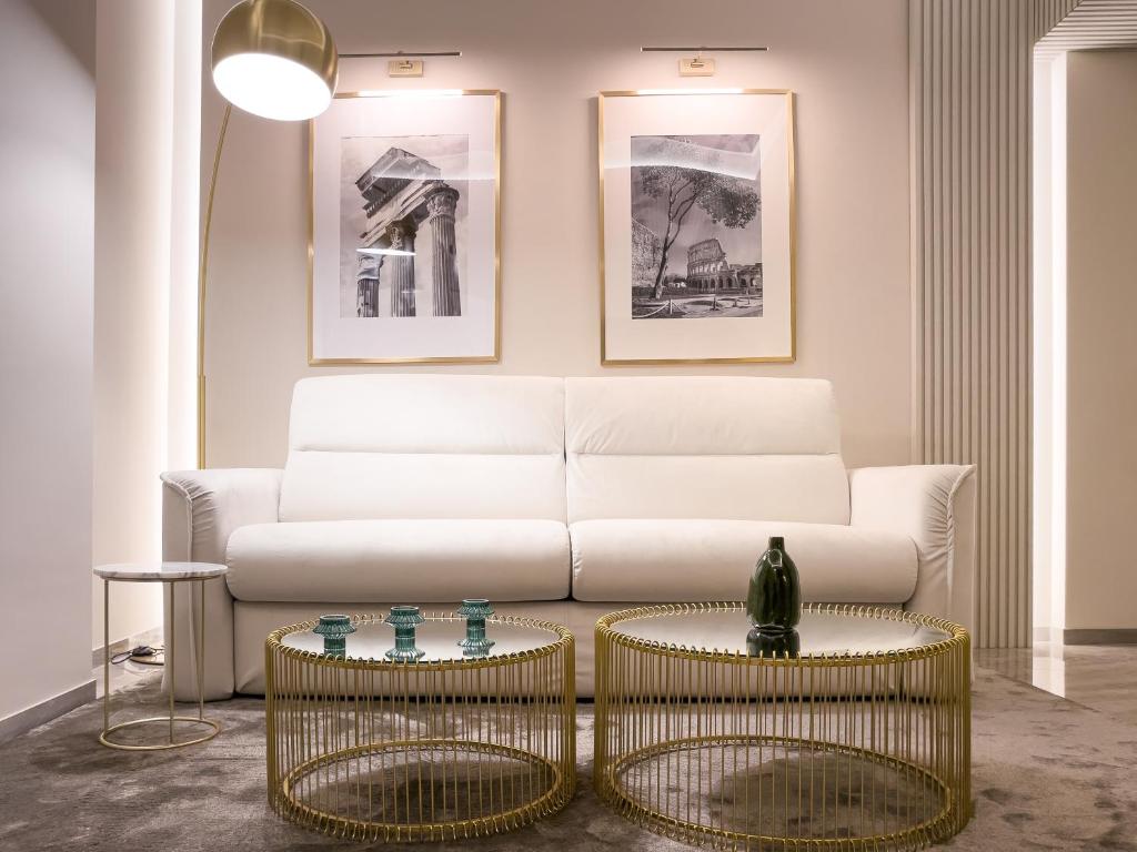Palazzo Venere في روما: غرفة معيشة مع أريكة بيضاء وطاولتين