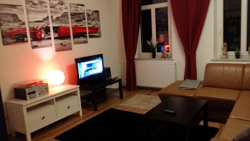 uma sala de estar com um sofá e uma televisão em Ferienwohnung Paschke Chemnitz Schönau em Chemnitz