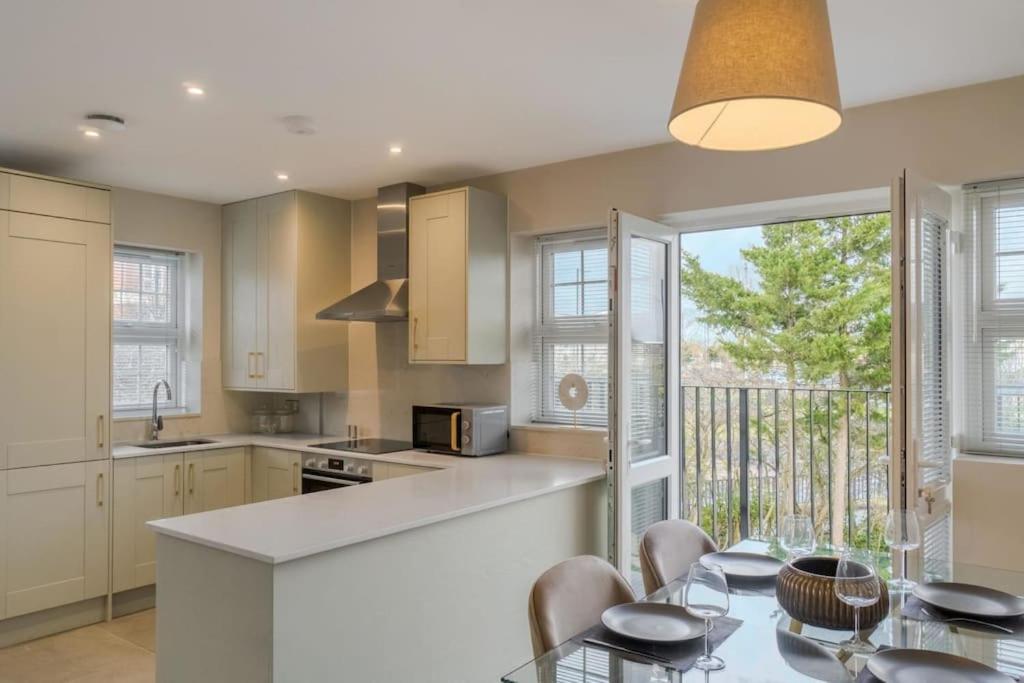 a kitchen with a table and chairs and a dining room at Stylish Windsor Getaway w/ Balcony - Free Parking in Windsor