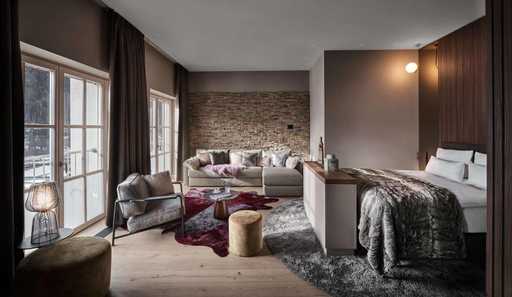 a bedroom with a bed and a brick wall at Grand Tirolia Kitzbühel - Member of Hommage Luxury Hotels Collection in Kitzbühel