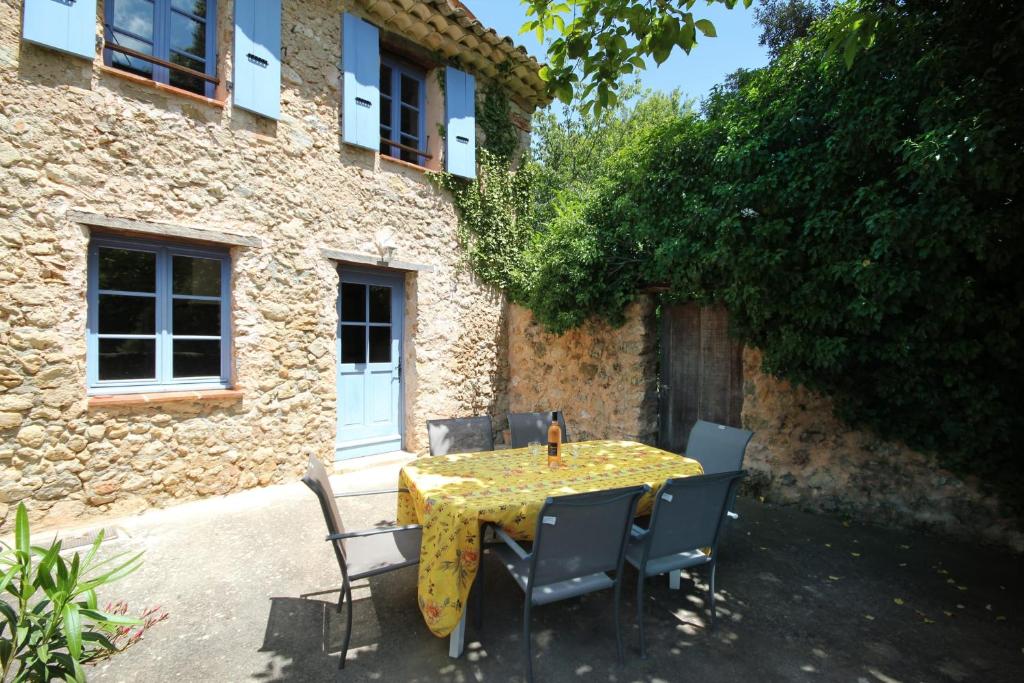 uma mesa e cadeiras em frente a um edifício em Lou Penequet a charming Mas in Provence with shared pool countryside em Flayosc