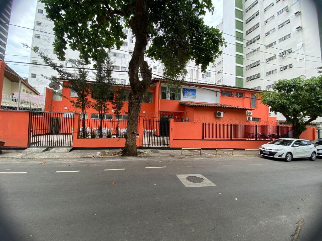 um edifício laranja com um carro estacionado num parque de estacionamento em Pousada Belo Mar em Salvador