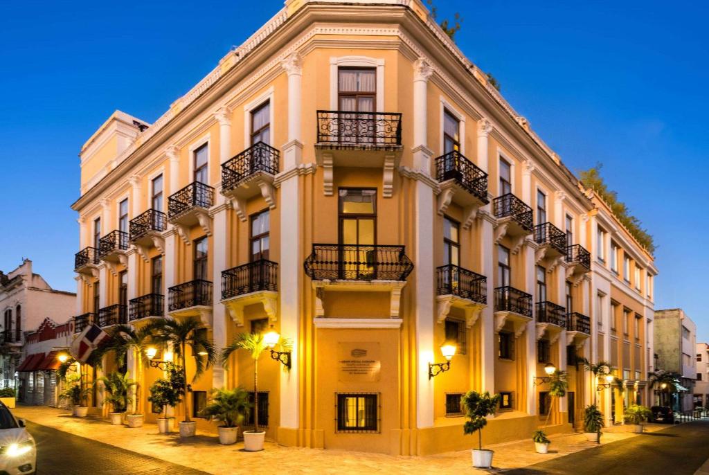 GRAN HOTEL EUROPA TRADEMARK COLLECTION by WYNDHAM في سانتو دومينغو: مبنى أصفر كبير مع شرفات على شارع