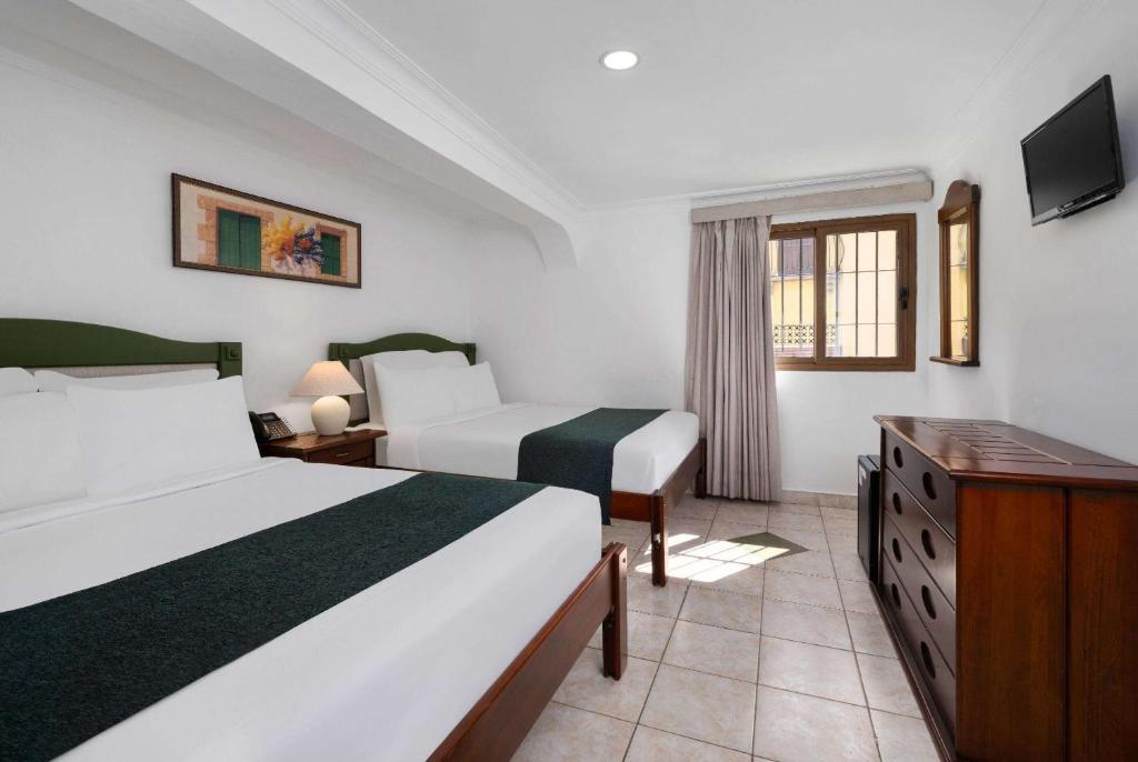 Postel nebo postele na pokoji v ubytování Gran Hotel Europa Santo Domingo Trademark Collection by Wyndham