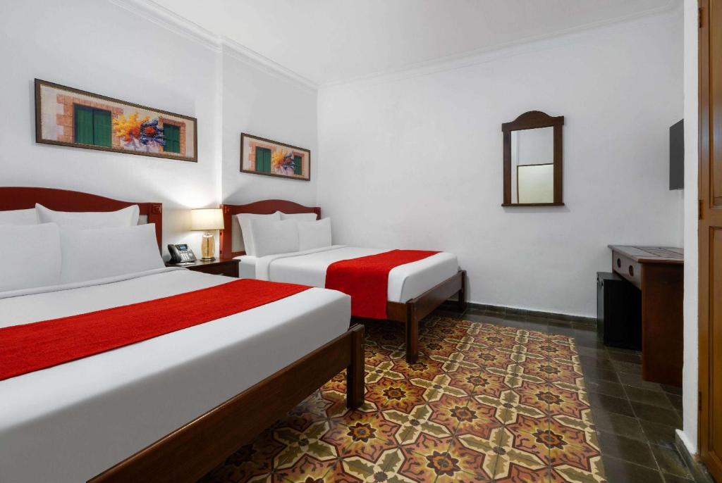 Postel nebo postele na pokoji v ubytování Gran Hotel Europa Santo Domingo Trademark Collection by Wyndham
