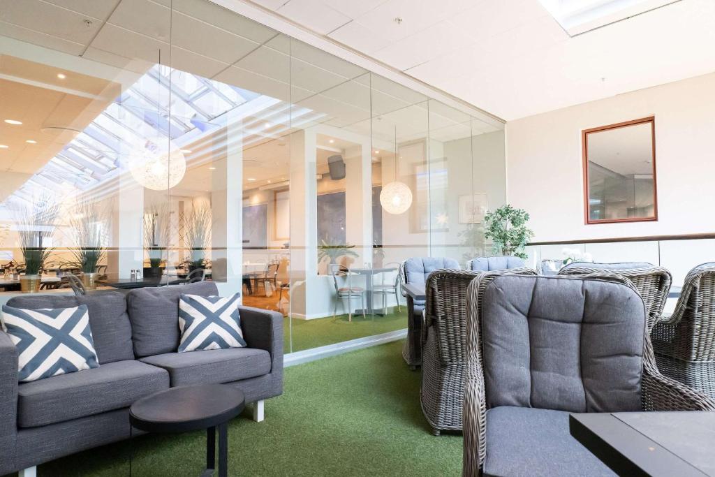 a waiting room with couches and a table and chairs at Best Western Plus Park City Solna in Solna