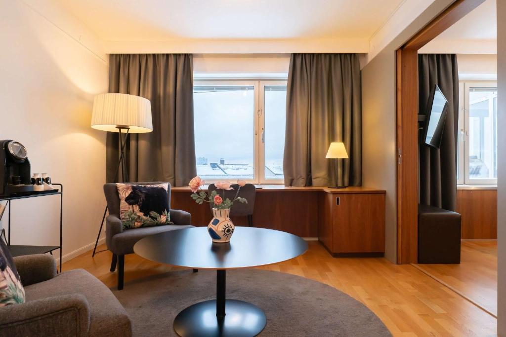 a living room with a couch and a table at Best Western Plus Park City Solna in Solna