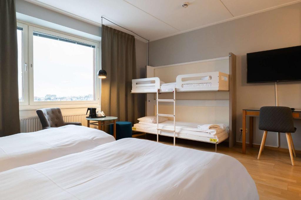 a hotel room with two beds and a flat screen tv at Best Western Plus Park City Solna in Solna