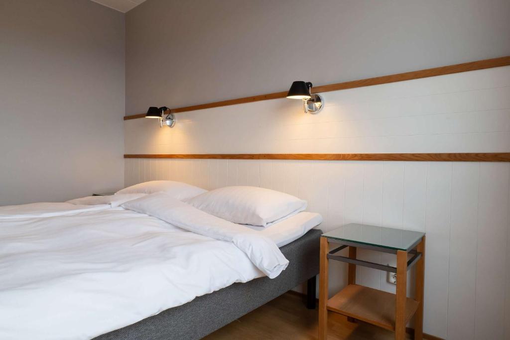 a bedroom with two beds and a side table at Best Western Plus Park City Solna in Solna