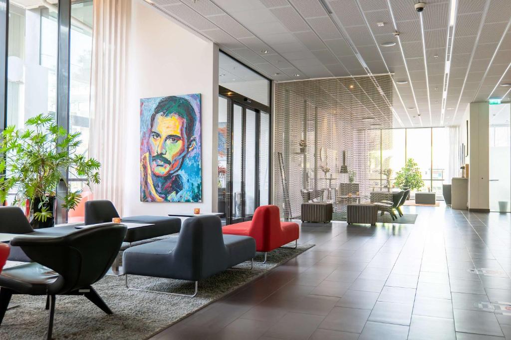 a lobby with chairs and a painting of a man at Best Western Plus Park City Malmö in Malmö