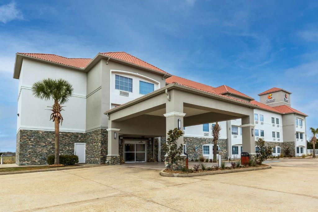 新伊比利亞的住宿－Comfort Inn & Suites New Iberia - Avery Island，前面有棕榈树的建筑