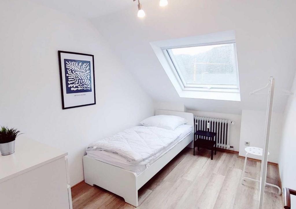 um quarto branco com uma cama e uma janela em DWK: Monteurhaus Bad Salzig em Boppard