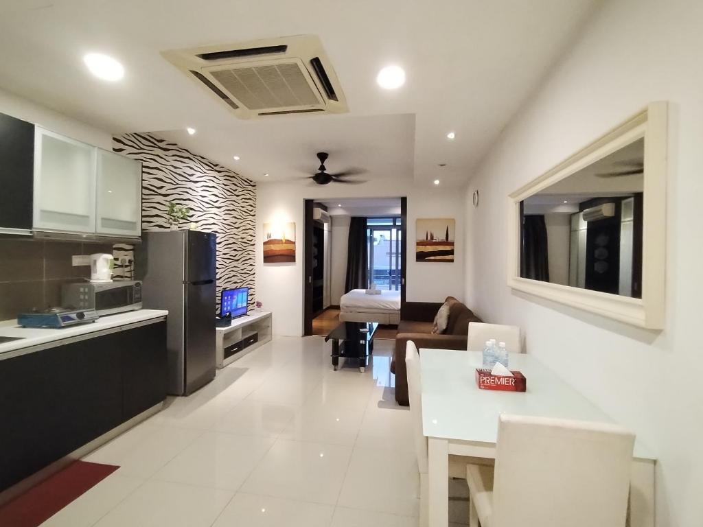 a kitchen and living room with a couch and a table at Taragon Time Service Suite in Kuala Lumpur