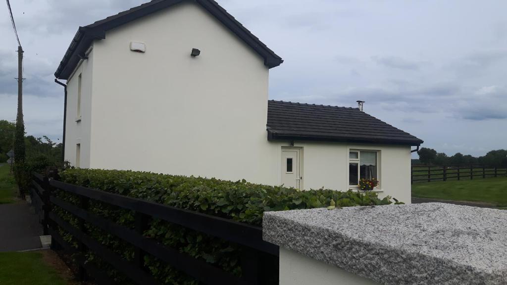 uma casa branca com um telhado preto em Clonard Cottage em Clonard