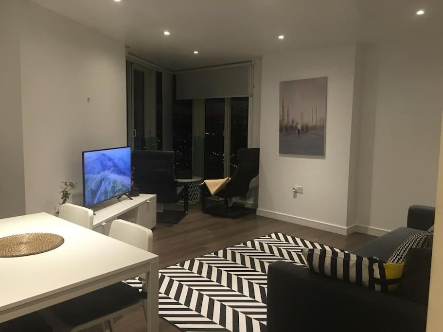 a living room with a television and a table and chairs at GRAND SERVICED APARTMENT***** in Croydon