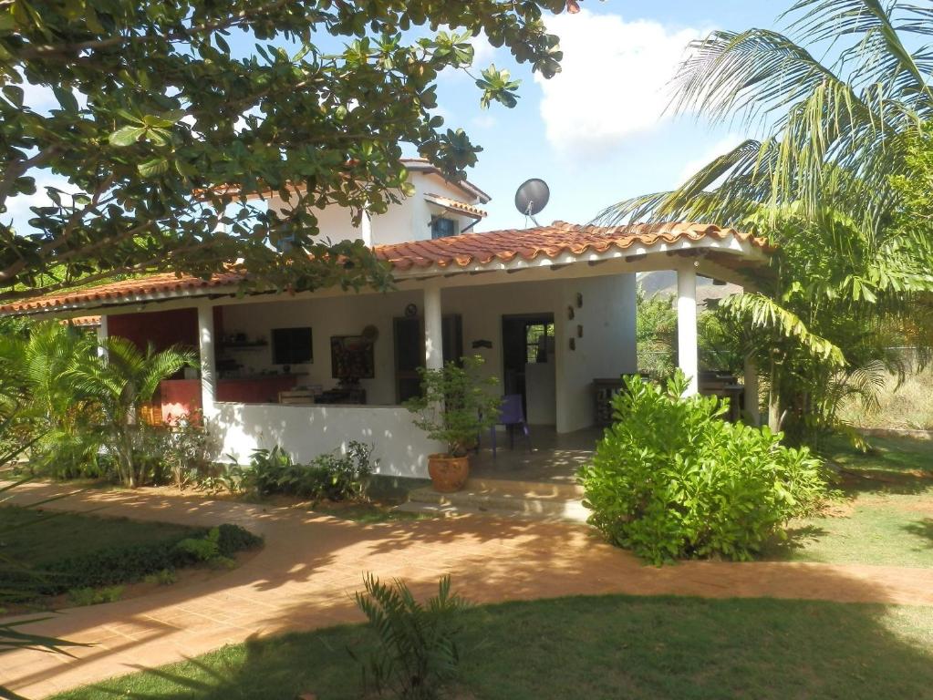 a white house with a red roof at Posada Casa Las Trinitarias in Paraguachi