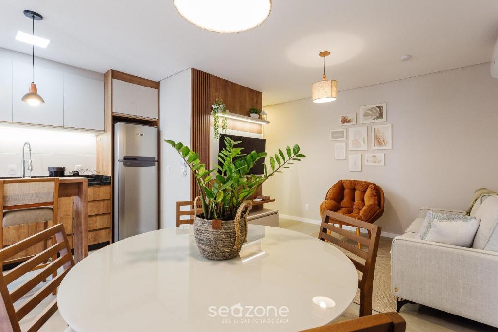 een keuken en een woonkamer met een witte tafel en een plant bij Apto 2 suítes próximo a praia Floripa-SC STN205 in Florianópolis