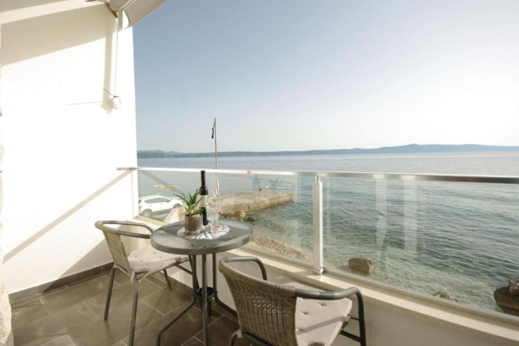 a balcony with a table and chairs and a view of the ocean at Harmony Drasnice in Drašnice