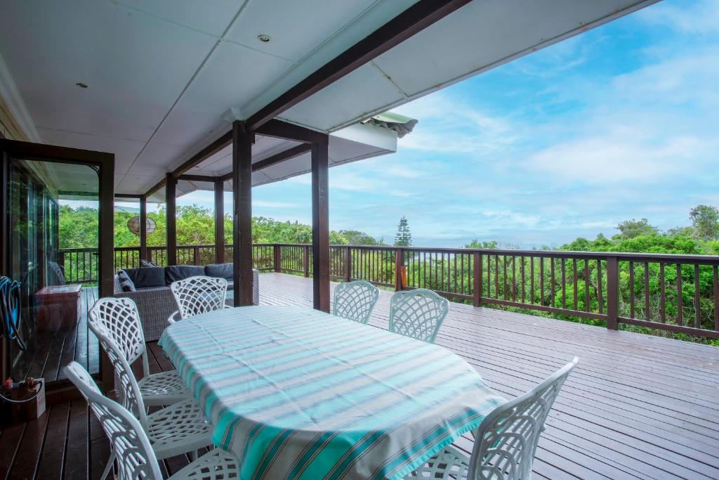 a patio with a table and chairs on a deck at Campismo Ninho 29 in Ponta Malongane