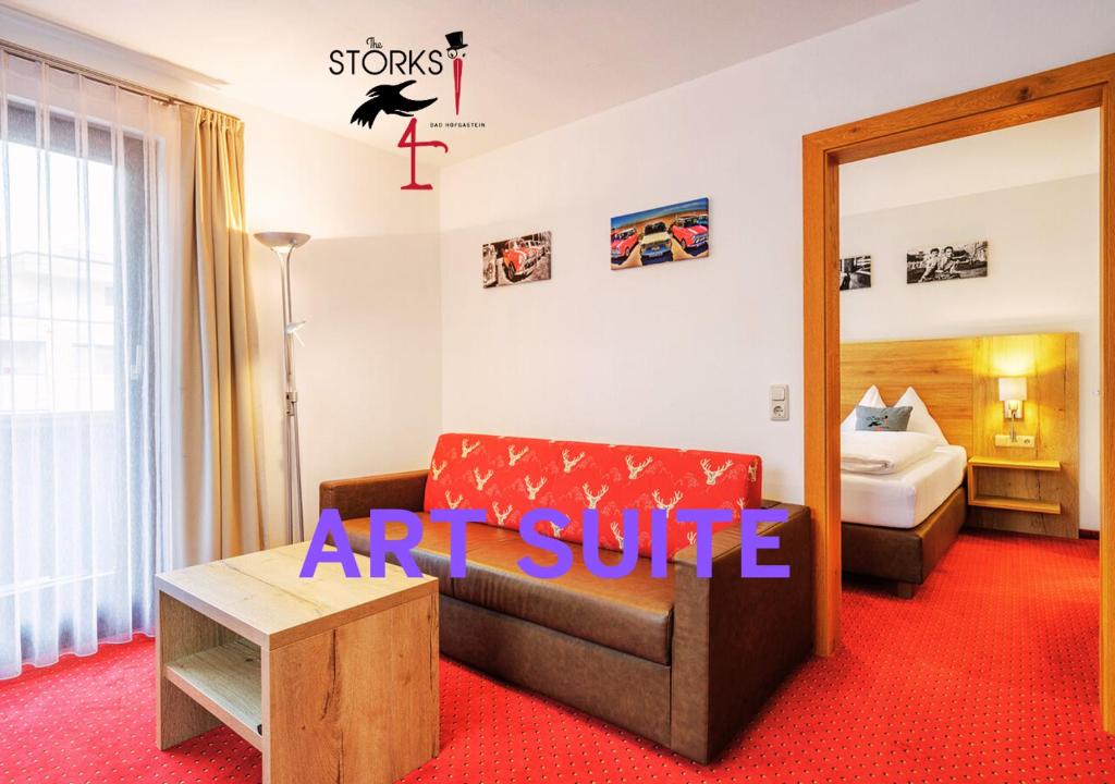 an art suite with a couch and a bed at Hotel Bad Hofgastein - The STORKS - Adults Only in Bad Hofgastein