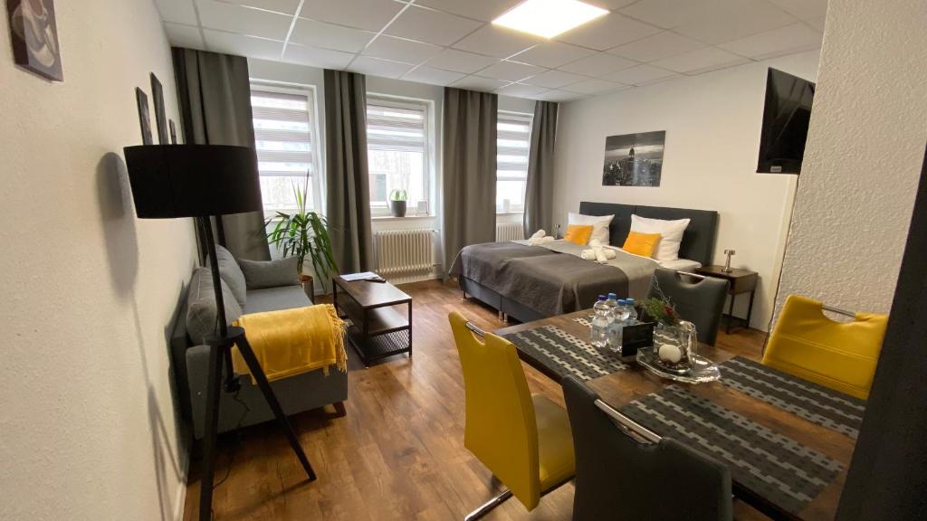 een woonkamer met een bed en een tafel en stoelen bij City Nowa 1 in Neurenberg
