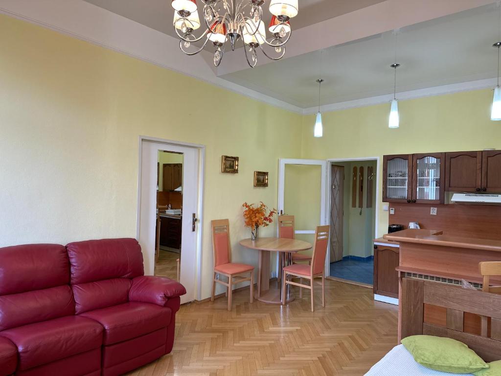 sala de estar con sofá rojo y cocina en Svahova 986/6, en Karlovy Vary