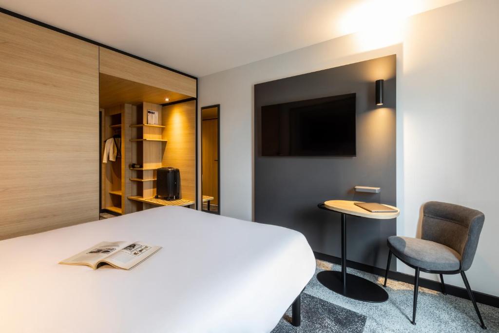 Un dormitorio con una cama, un escritorio y una silla. en ibis Nancy Centre Stanislas, en Nancy