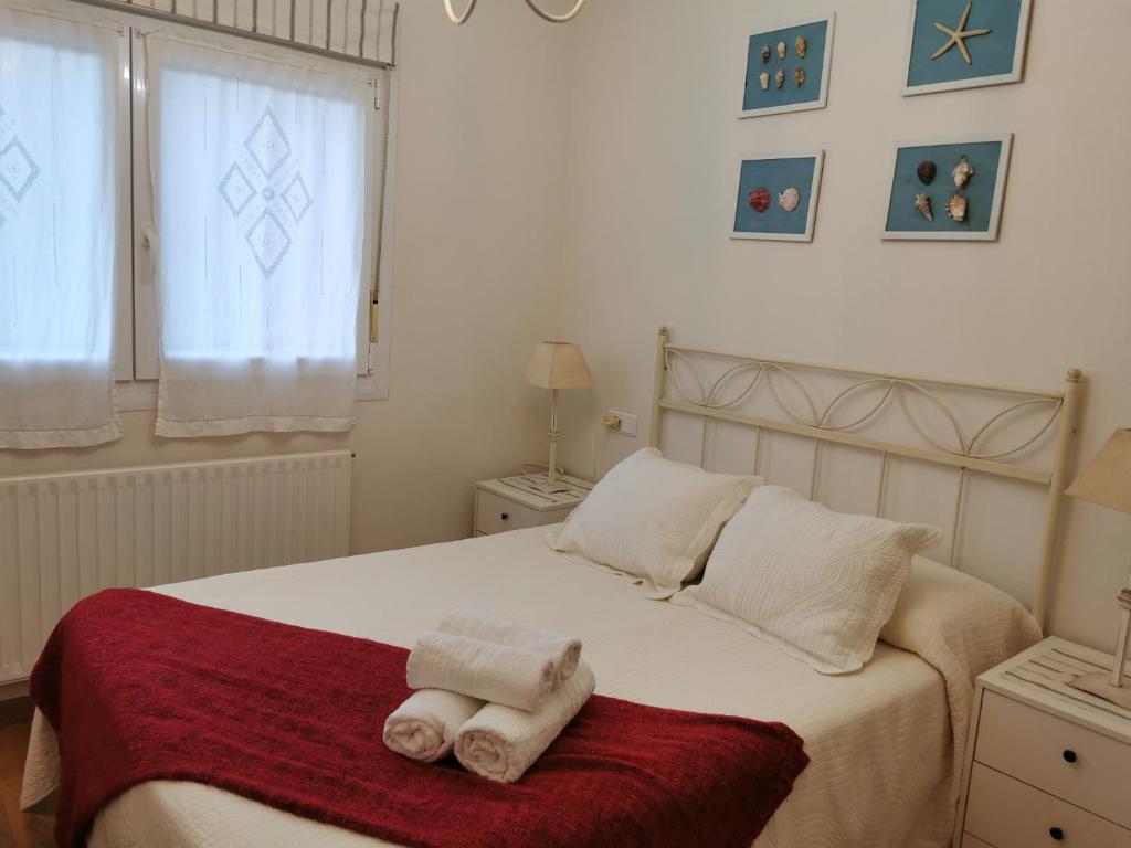 利亞內斯的住宿－LUCES DE LLANES，一间卧室配有带毛巾的床