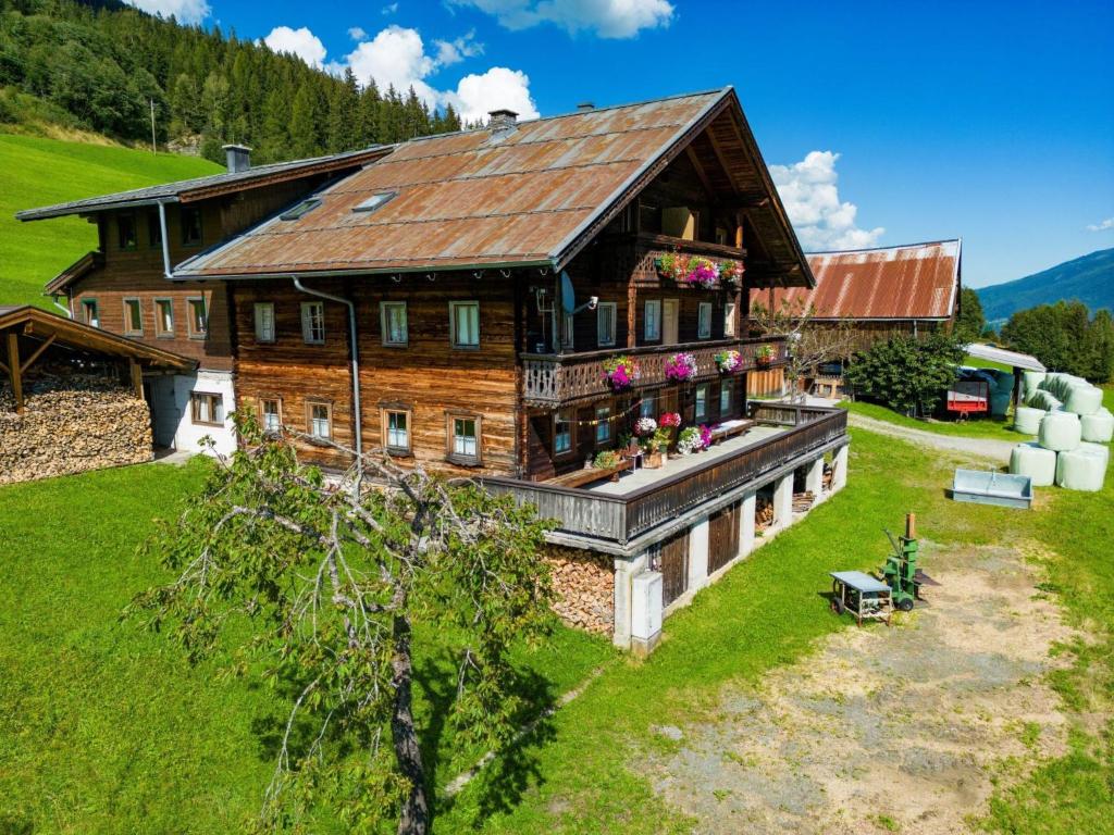 a large wooden house with flowers on the balcony at Holiday Home Moosen - NKI210 by Interhome in Neukirchen am Großvenediger
