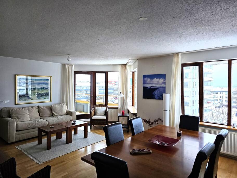 a living room with a couch and a table at Family penthouse with great view in Garðabær