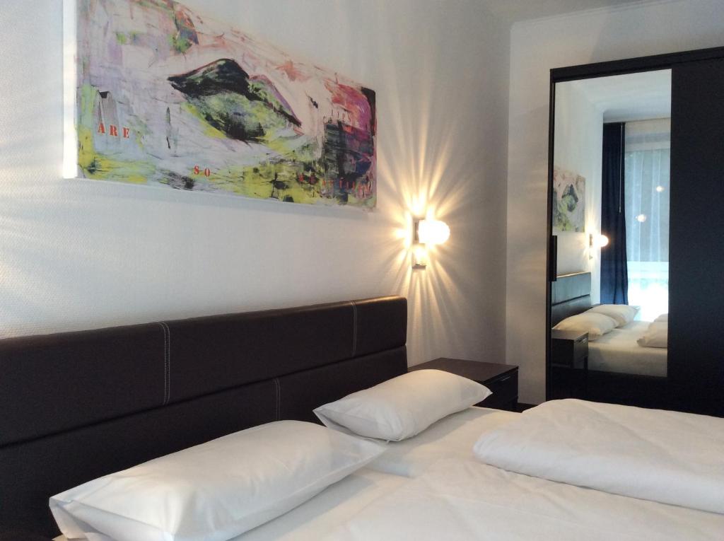 1 dormitorio con cama y espejo grande en Hotel52 Bergheim, en Bergheim