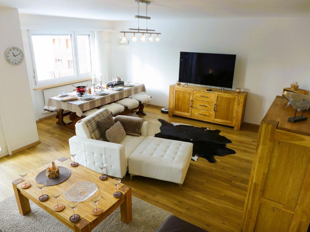 ein Wohnzimmer mit einem Sofa und einem TV in der Unterkunft Apartment Vermala-Soleil A-B-4 by Interhome in Vermala